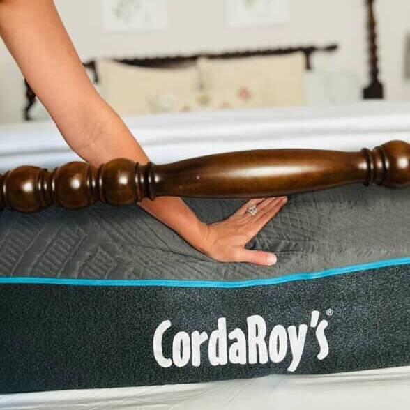 Person adjusting a wooden bed post on a CordaRoy's mattress