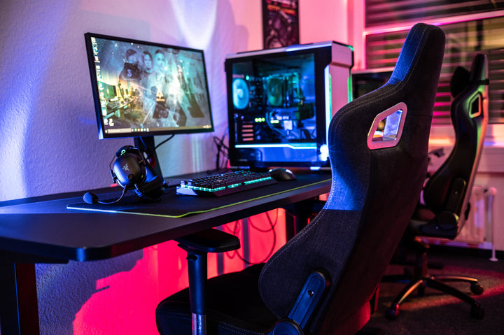 A gaming chair at a desk with LED lights and a gaming PC. 