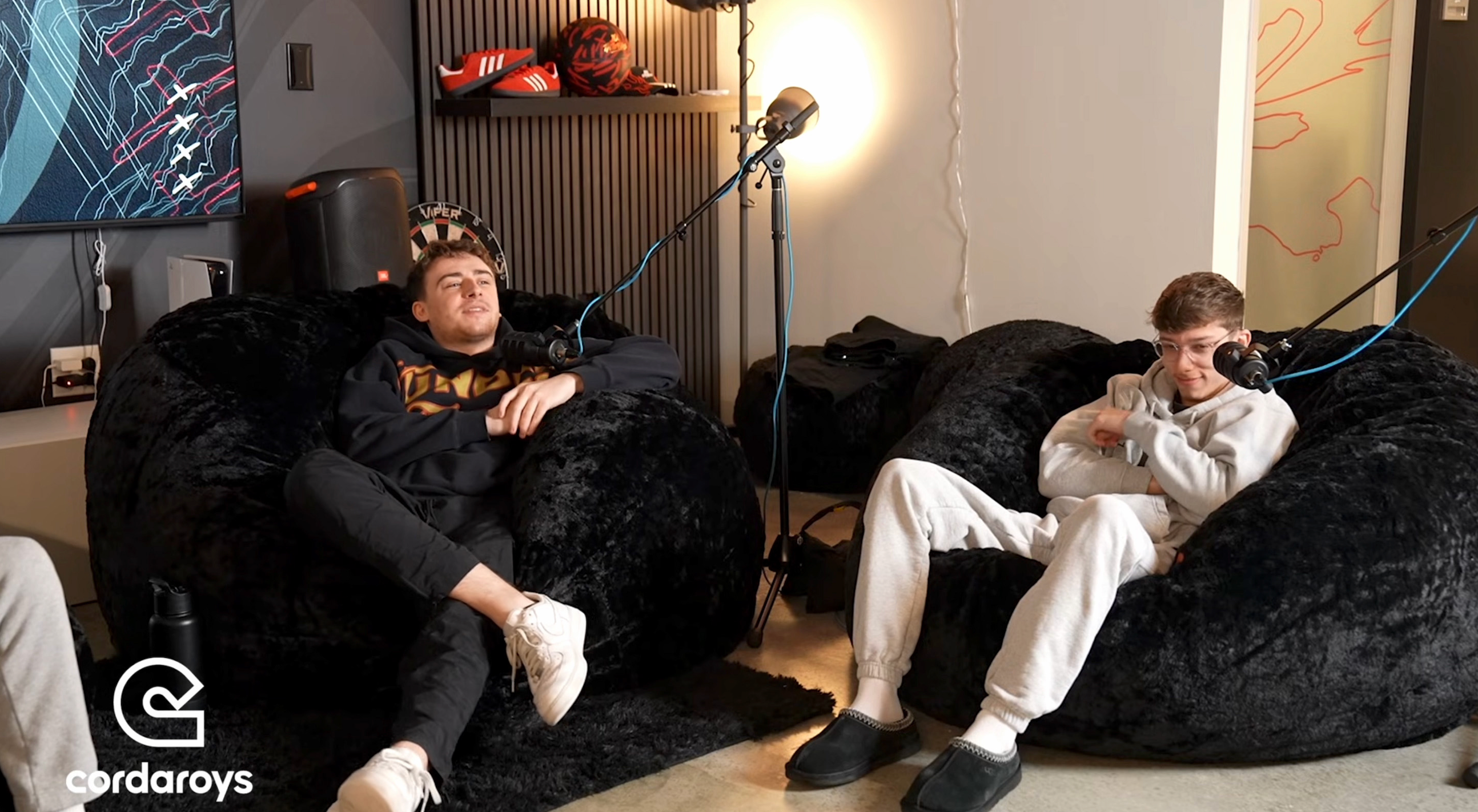 Two members from 100Thieves (LA Thieves) sit on cordaroys bean bag chairs during a podcast. 
