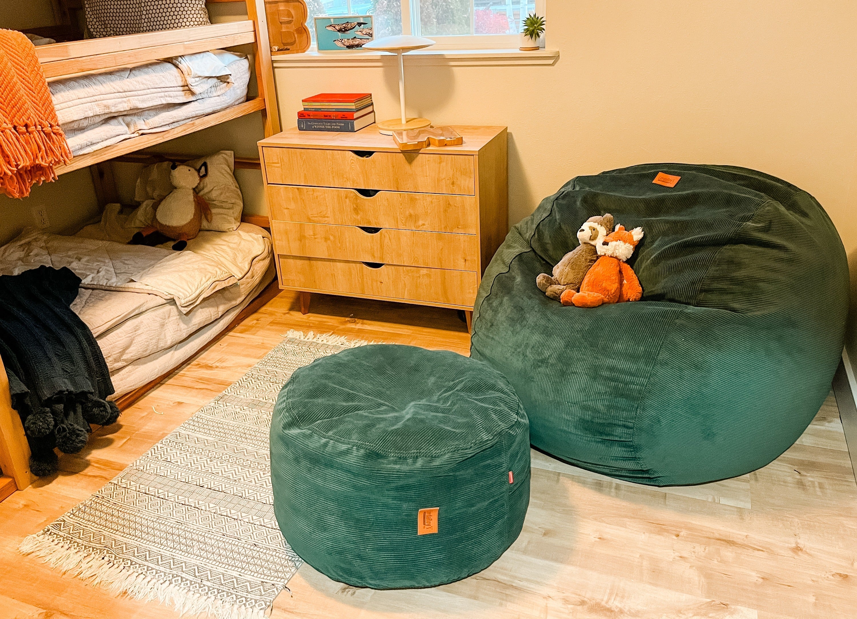 A cordaroys bean bag chair in a boys room with a bunk bed and stuffed animals.