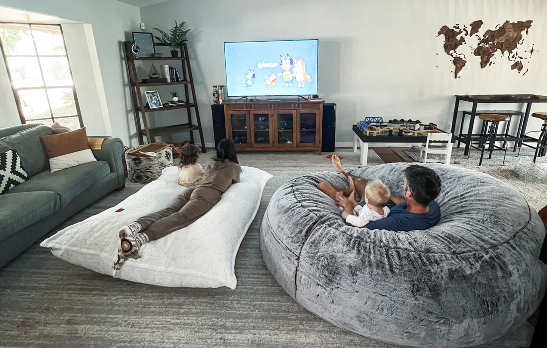 A family watches Bluey on their cordaroys bean bag chairs