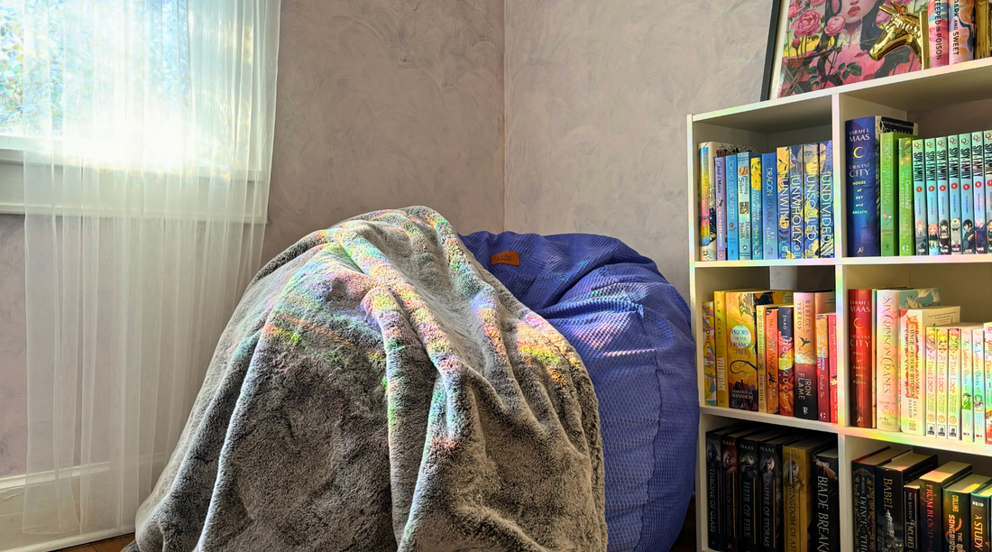 Bookshelf lined with books in a room with a cordaroys bean bag chair. 