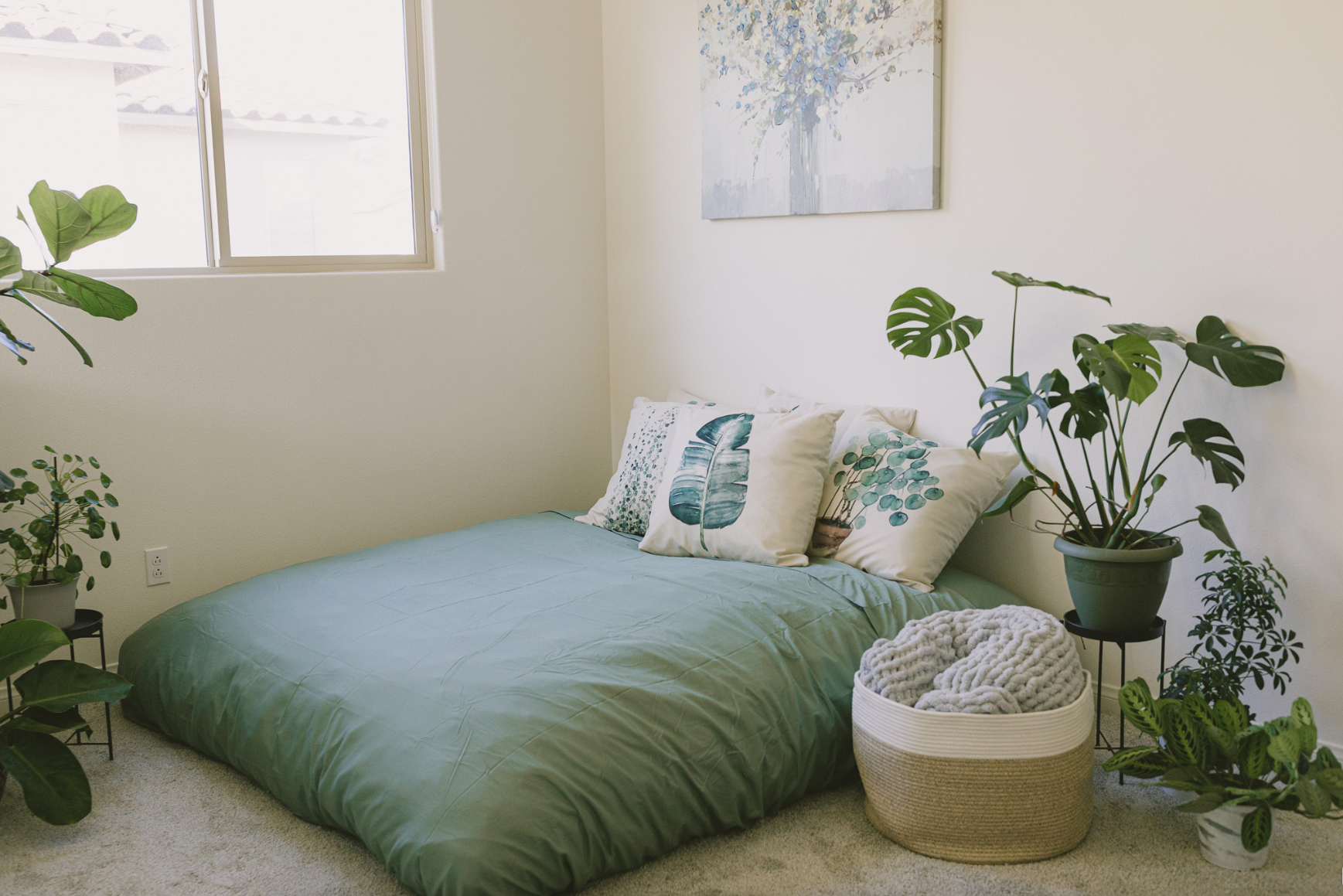 A cordaroys bean bag in mattress form layered with blankets and pillows. 