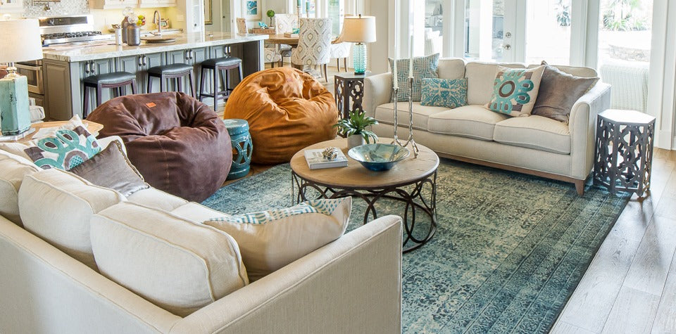 Two bean bag chairs used as a sofa alternative, paced in between two sofas in a living room.
