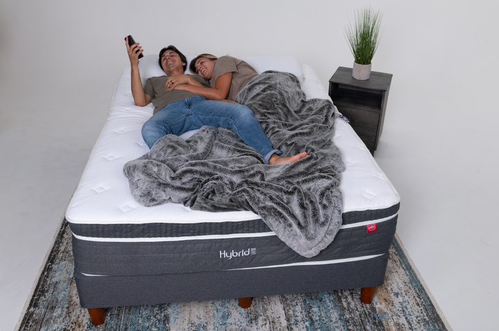 A couple on a CordaRoy's queen sized mattress in a room to simulate a guest bedroom.