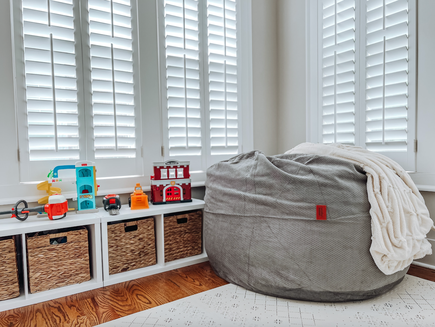 A cordaroys bean bag in the corner of a playroom. 