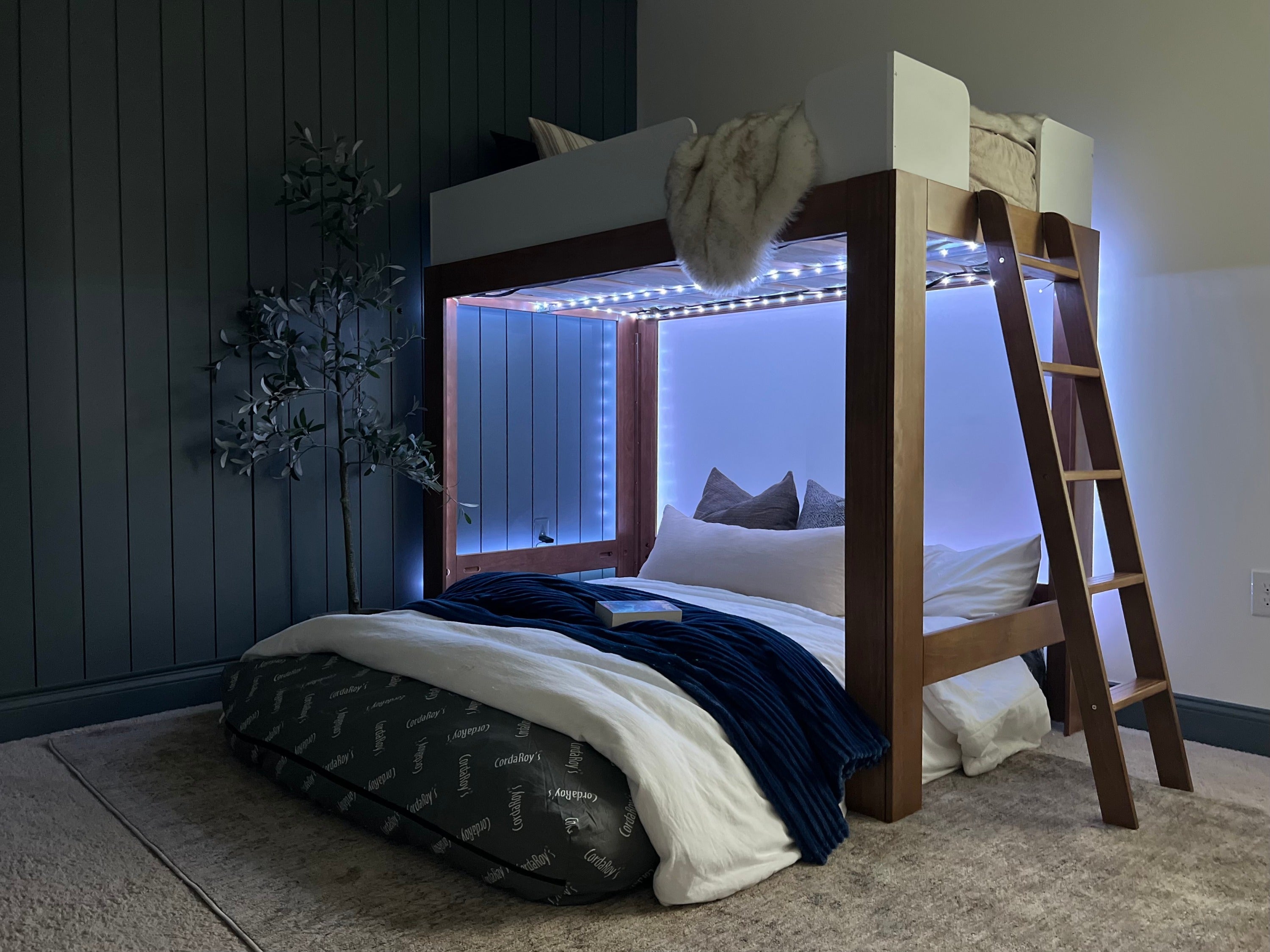 A cordaroys bean bag under a loft bed in bed form