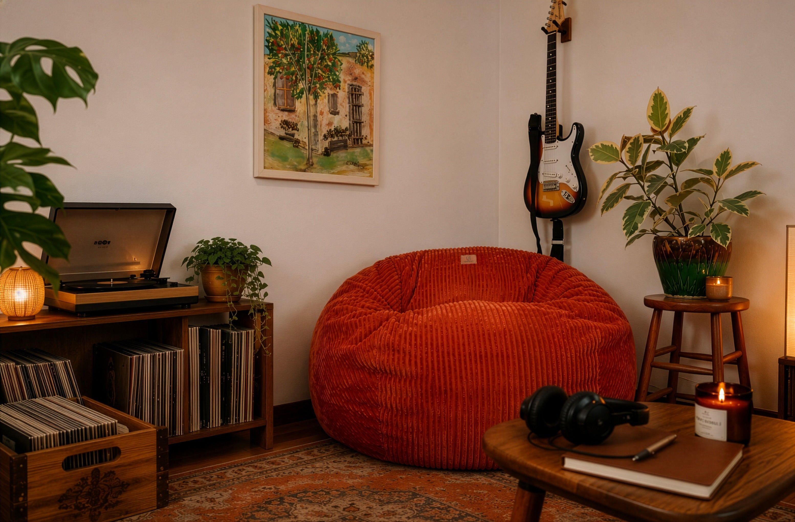 A cordaroys bean bag chair in the middle of a music room with records and a guitar. 