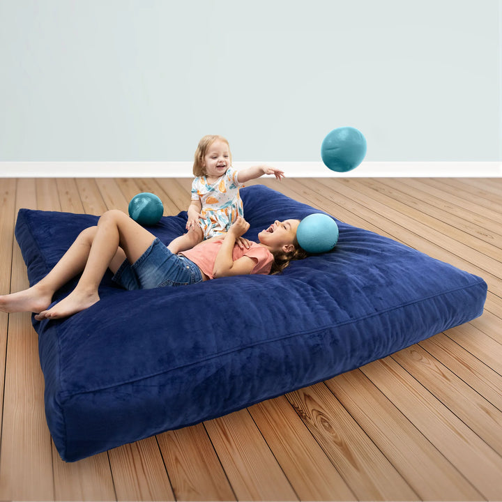 Two children playing on a CordaRoys crash pad. 