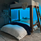 A cordaroys full bean bag is in bed form under a bunk bed. 
