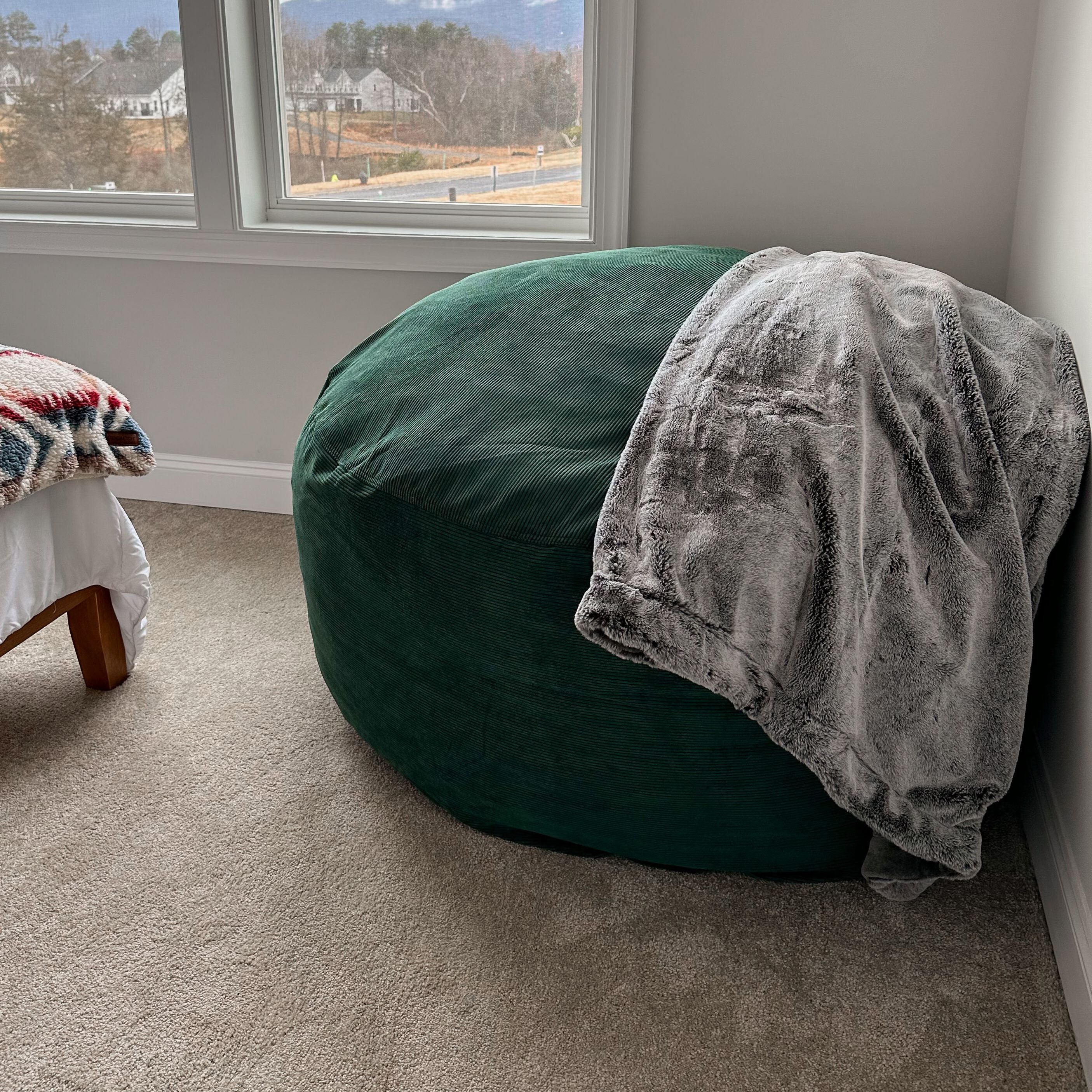 A cordaroys full corduroy bean bag in a bedroom corner. 