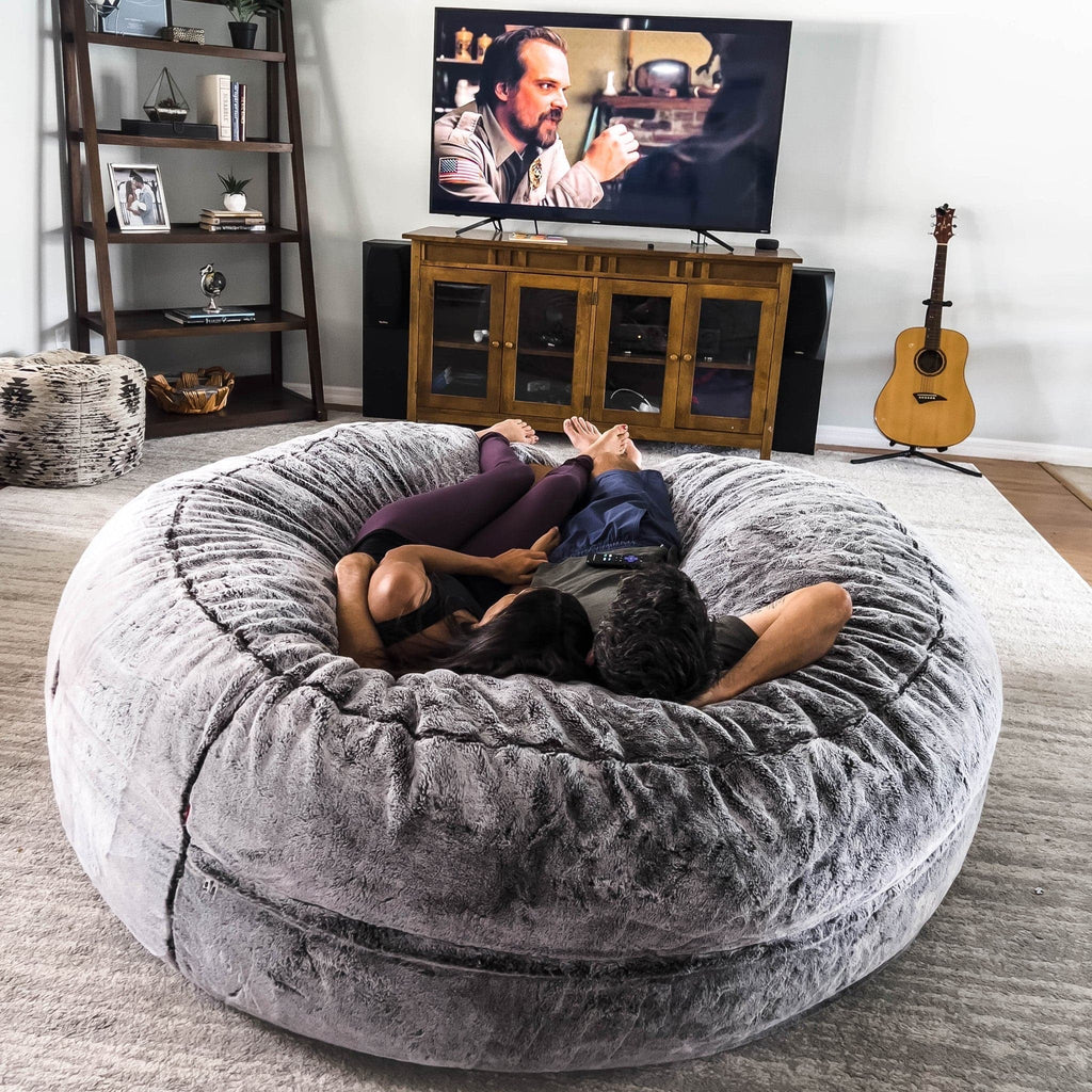 Two people cuddle on a cordaroys chinchilla giant bean bag