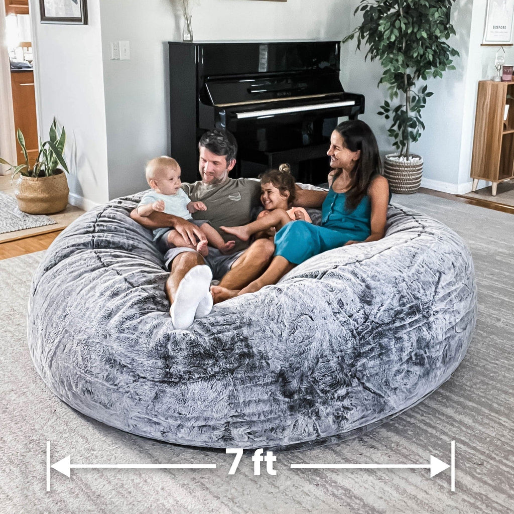 A family of four sits on a cordaroys chinchilla giant bean bag.