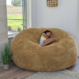 A girl sits on a cordaroys plush corduroy giant bean bag chair in tan. 