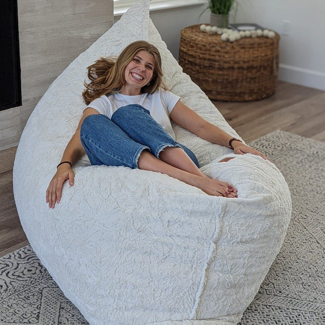 A woman relaxes on a cordaroys pillow launcher in faux fur. 