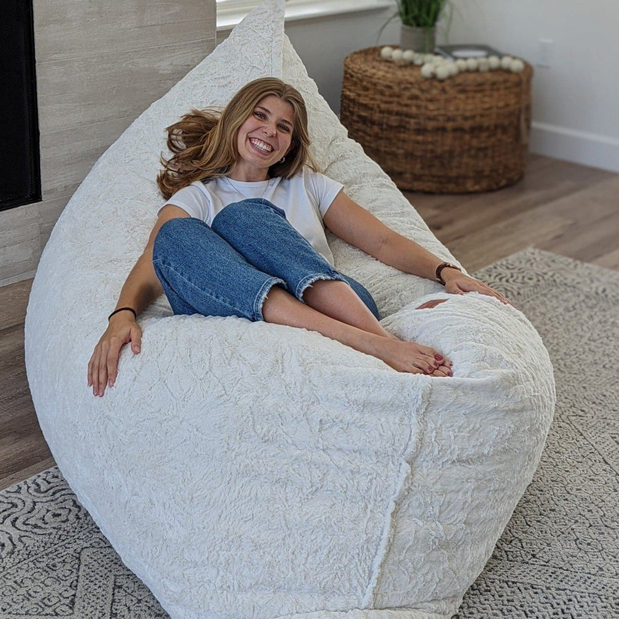 A woman relaxes on a cordaroys pillow launcher in faux fur. 