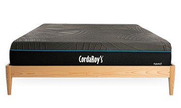 Mattress on a wooden bed frame with CordaRoy's branding.