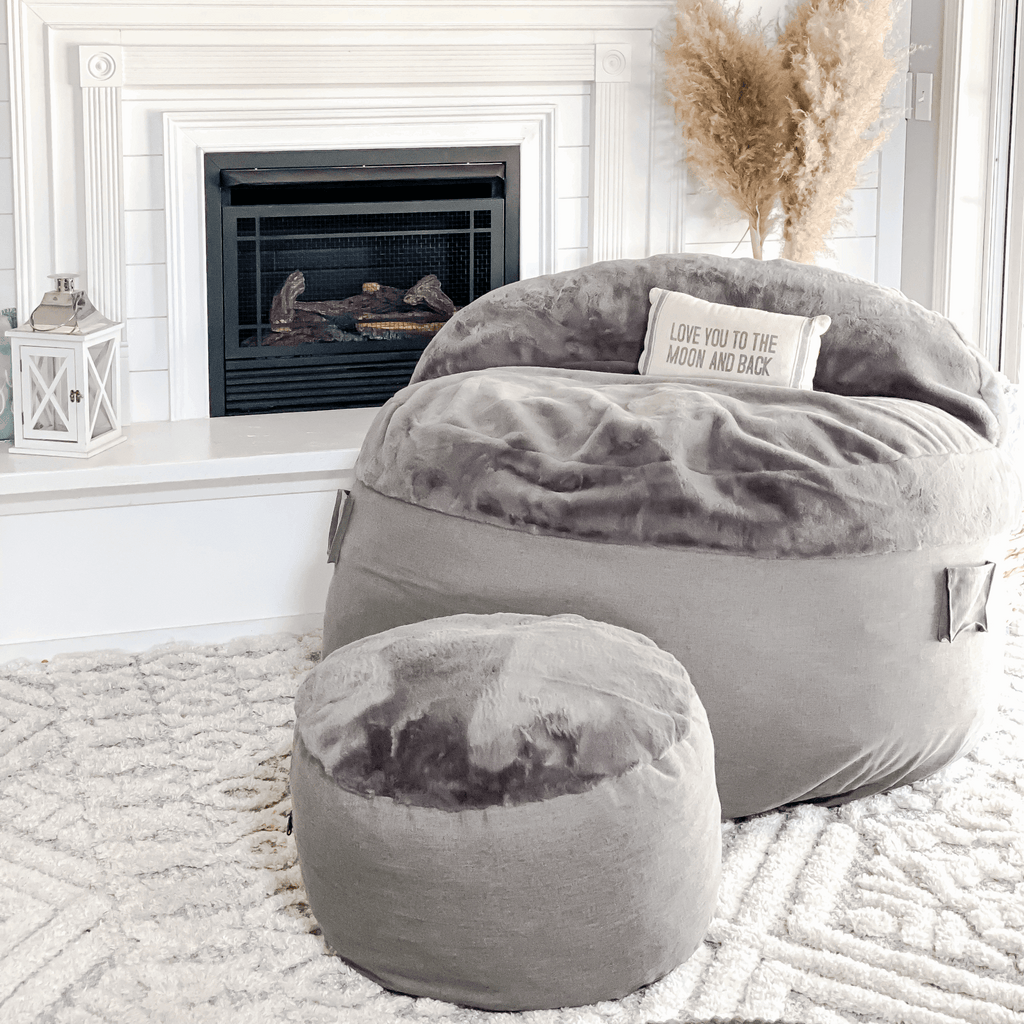A cordaroys NEST chair and footstool in charcoal bunny fur in a living room. 